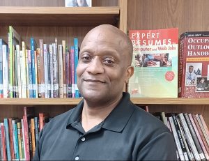 Michael standing in front of a book shelf.